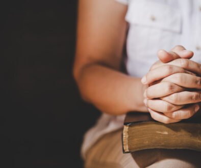 Spirituality and religion, Hands folded in prayer on a Holy Bibl