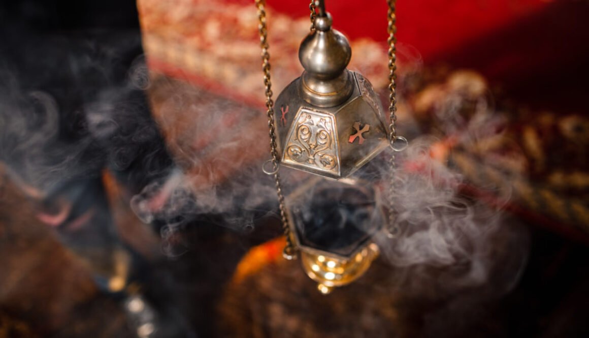 A priest's censer hangs on an old wall in the Orthodox Church. Copper incense with burning coal inside. Service in the concept of the Orthodox Church. Adoration