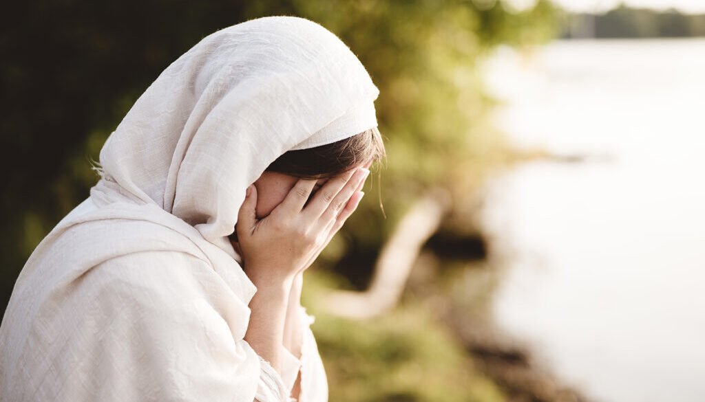 Closeup shot of a female wearing biblical robe crying - concept confessing sins