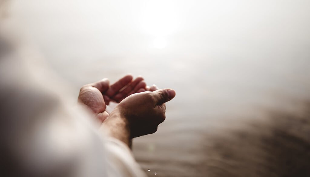 High angle shot of Jesus Christ holding water with his palms