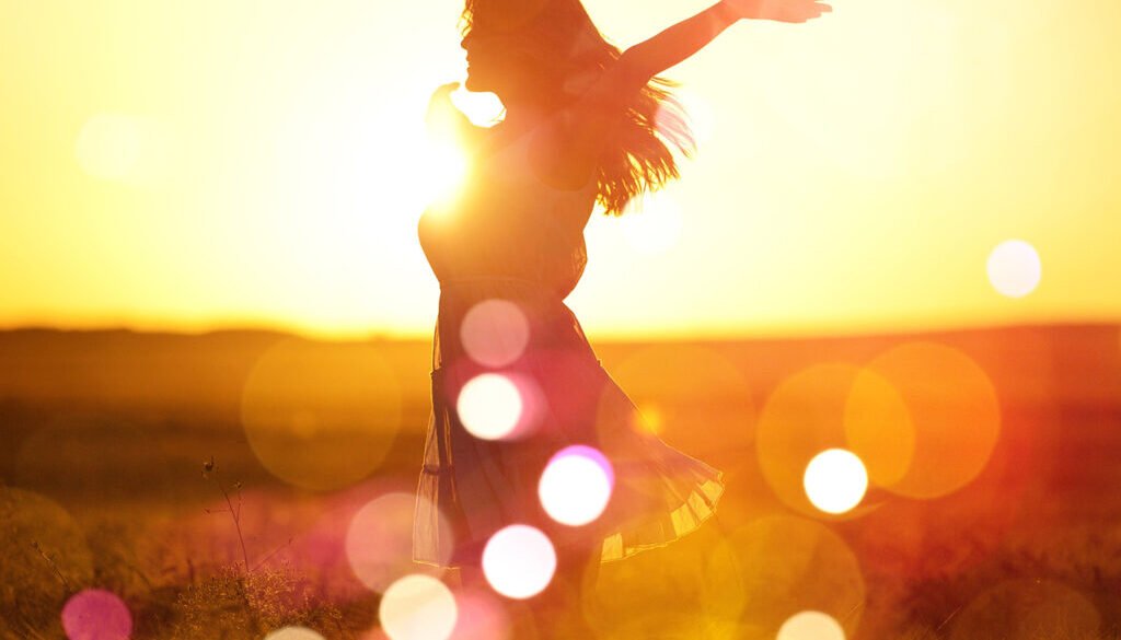 Young woman on field under sunset light