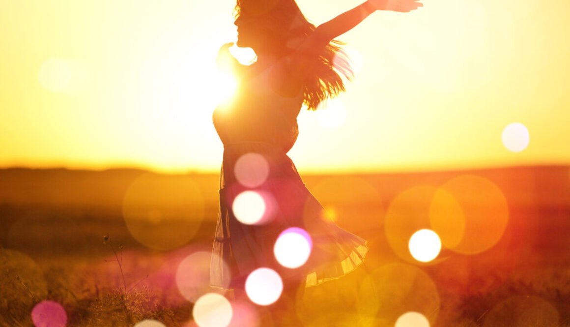 Young woman on field under sunset light