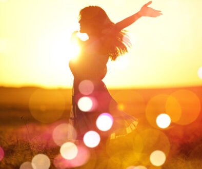 Young woman on field under sunset light